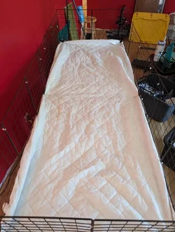 The same matress topper cliped into place. along the edges of the cage using 6 binder clips. 2 on each end and 2 in the middle. The same matress topper cliped into place. along the edges of the cage using 6 binder clips. 2 on each end and 2 in the middle.